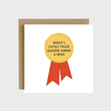 Load image into Gallery viewer, A funny greeting card featuring a ribbon award and text that reads, World’s fastest faller asleeper during a movie.